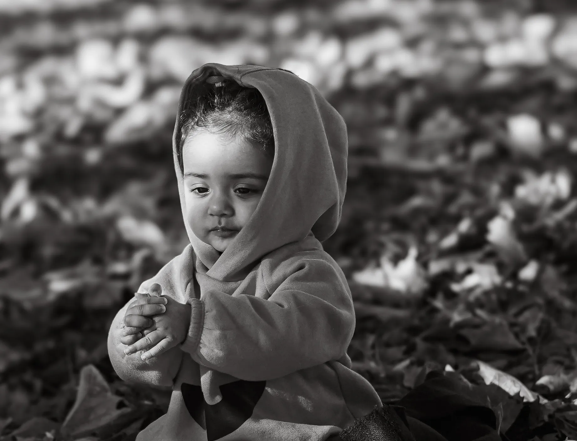 A black-and-white outdoor portrait of a young child