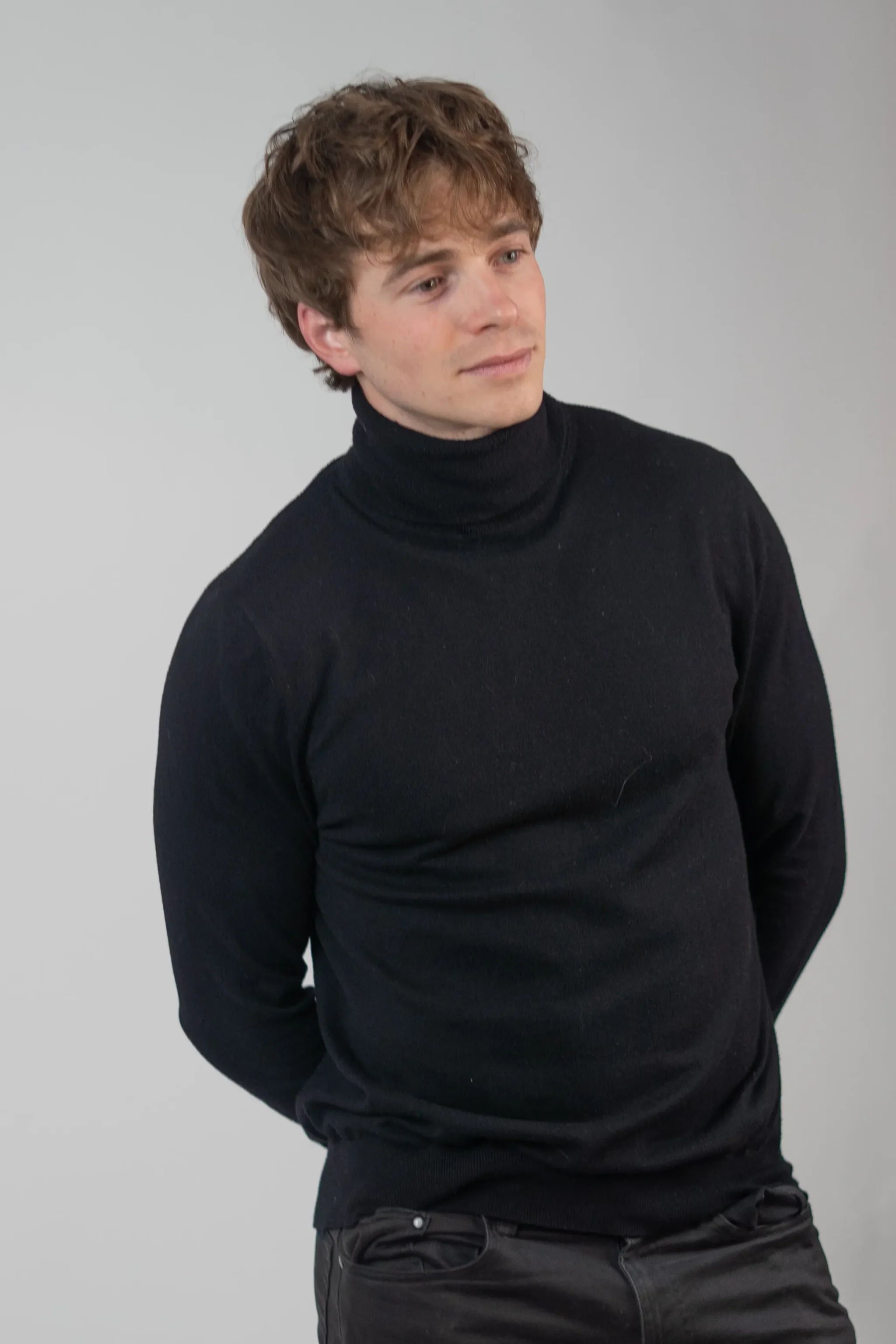 Studio portrait of a person wearing a black turtleneck